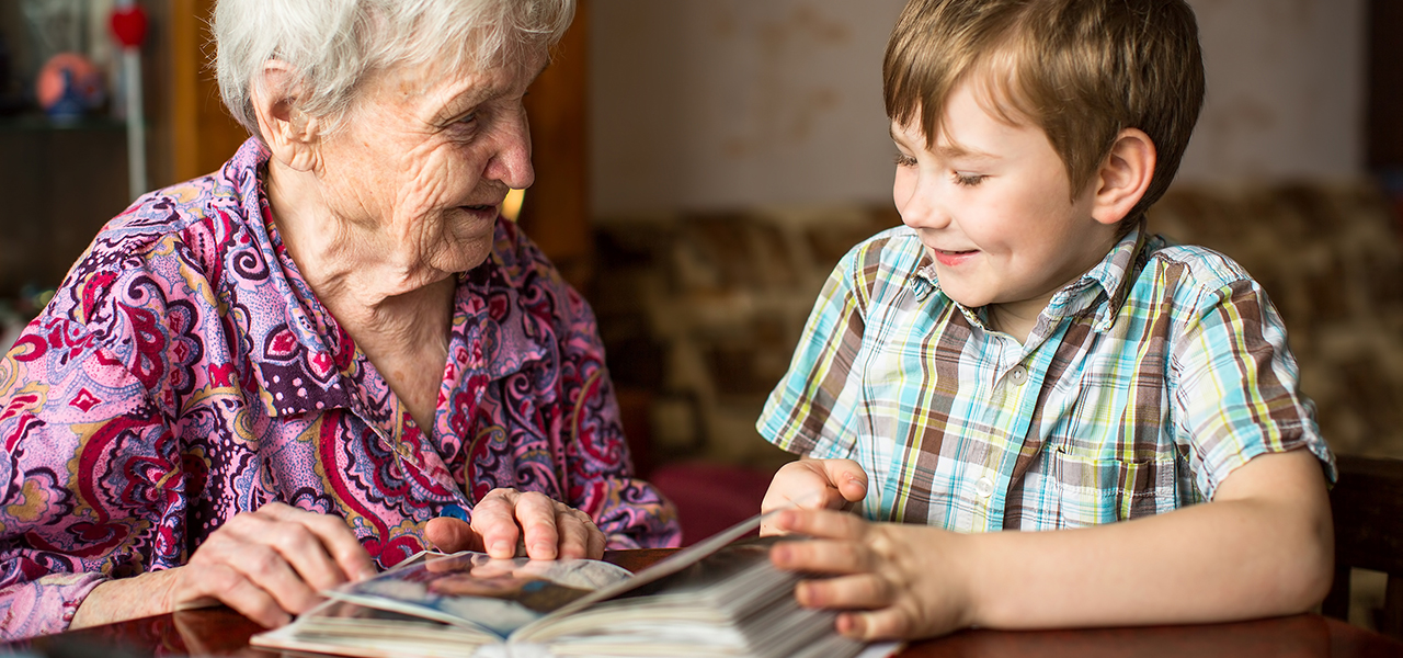 Grandma shows photo album to little grandson.