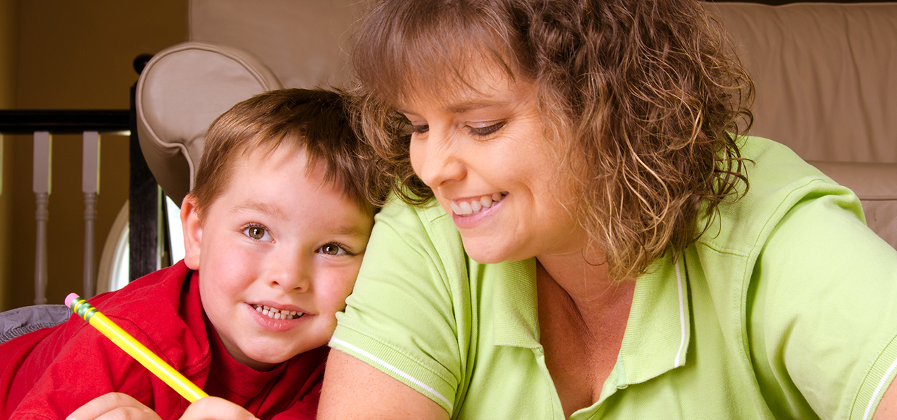 Mother helping child with writing lesson