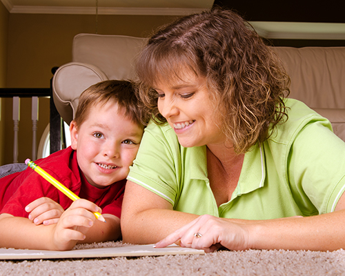 Mother helping child with writing lesson