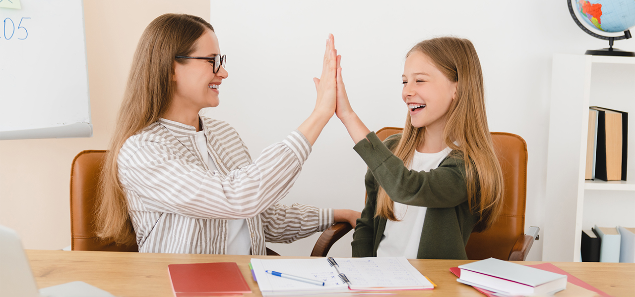 Mom giving high-five to daughter at homeschool