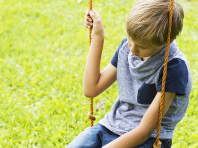 Sad,Lonely,Boy,Sitting,On,Swings.,Close,Up.