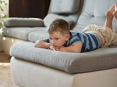 Calm boy lies on the sofa